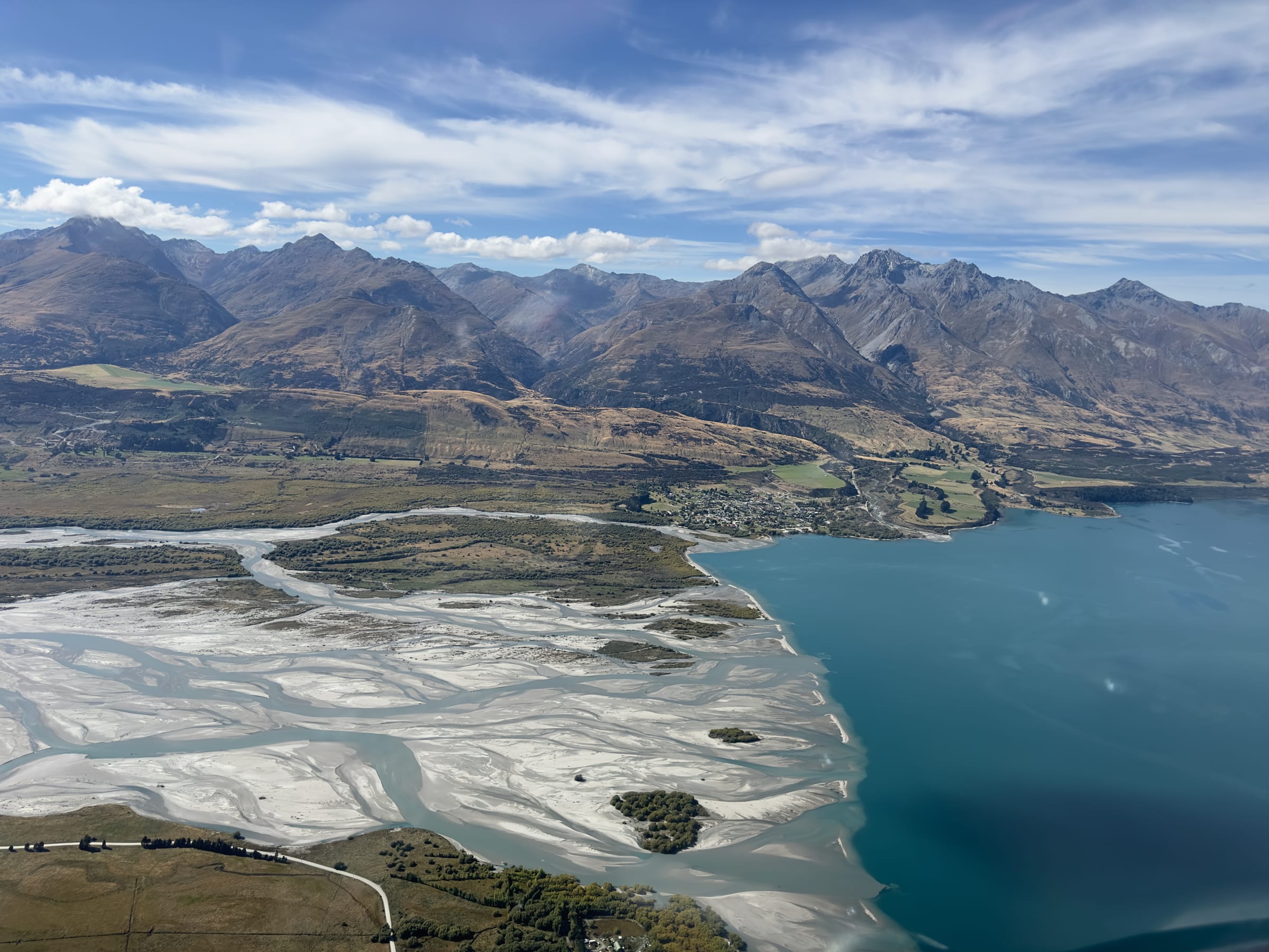 Aerial of braided river delta into turquoise lake