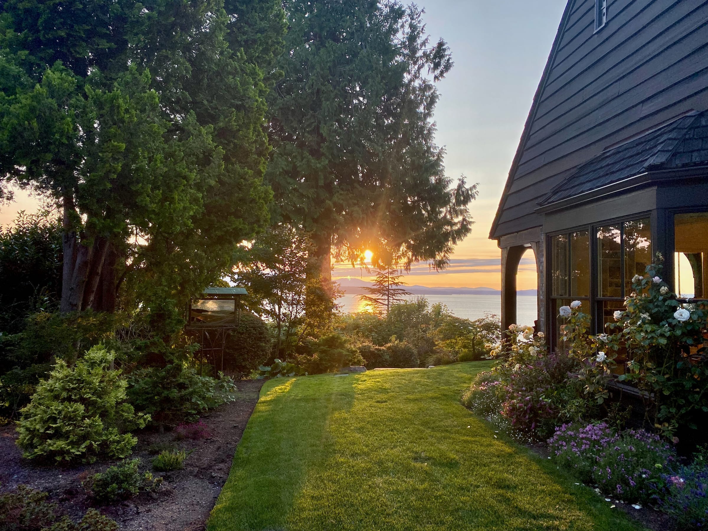 Garden and house at sunset with water view