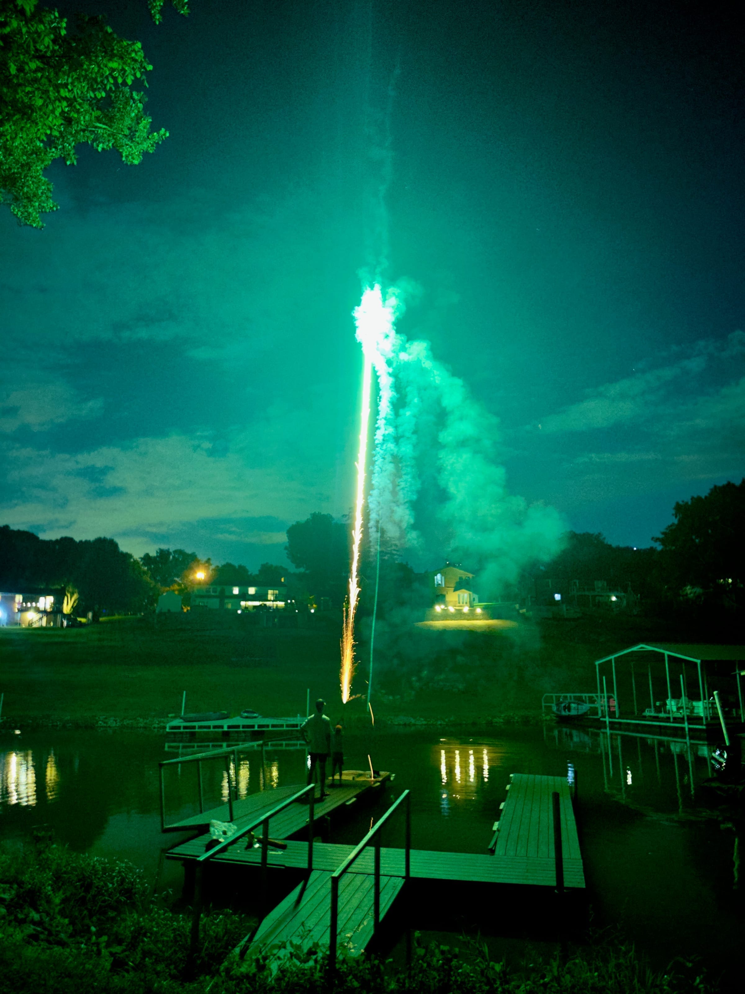 Fireworks launching from a lake dock