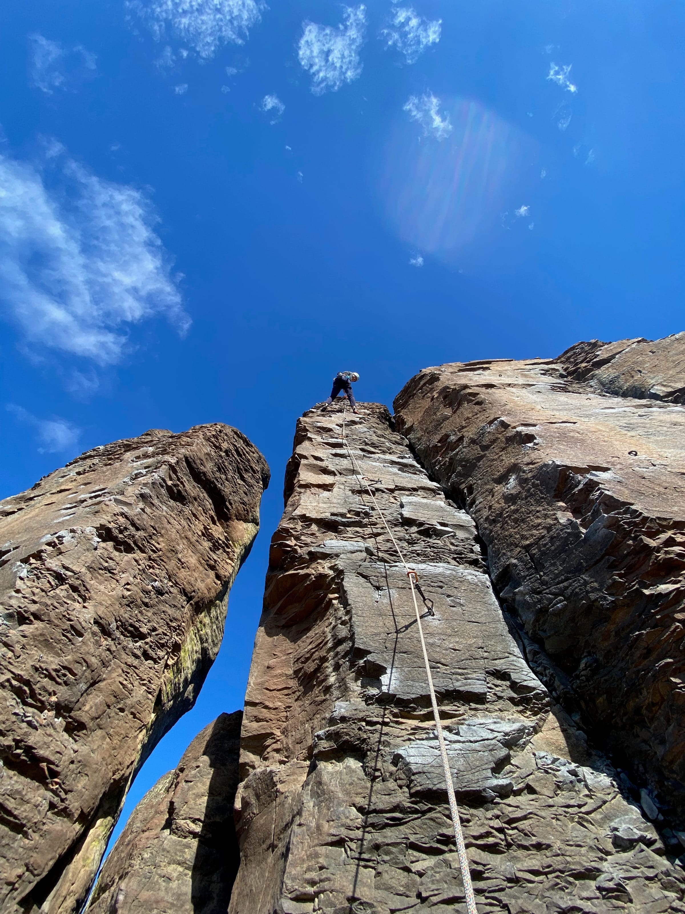 Rock climber ascending a tall column
